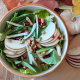 Fall Harvest Salad with Revolution Farms lettuce, apple slices, walnuts, and other ingredients.
